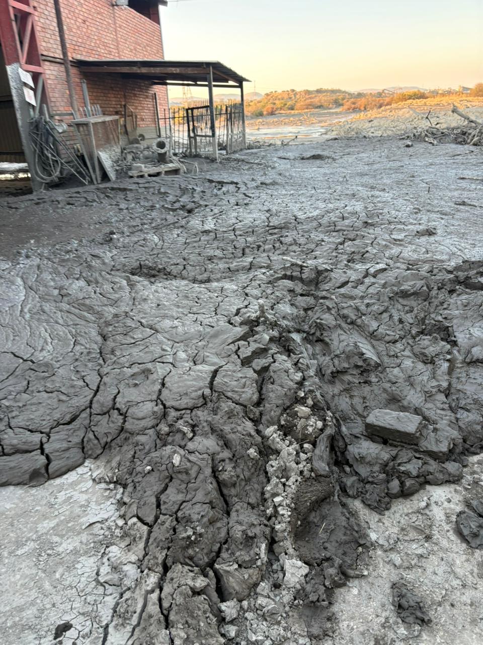 Sludge-covered outdoor area beside a brick industrial building
