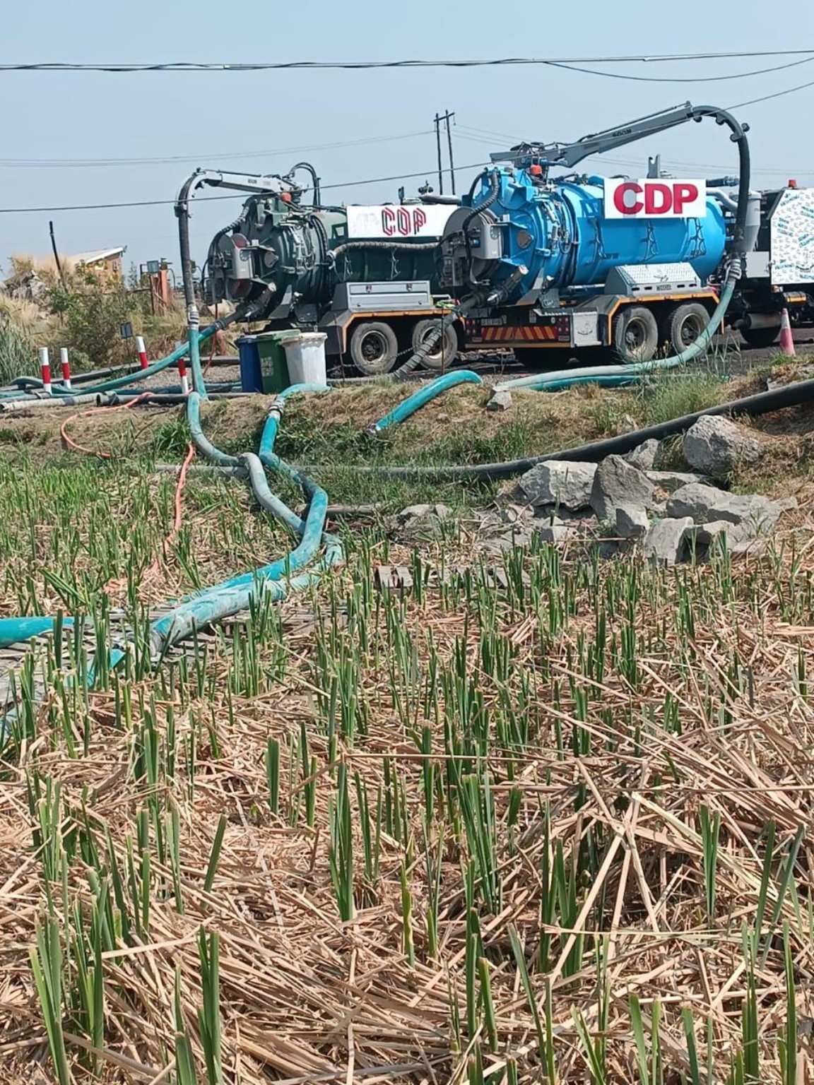 CDP vacuum tankers connected to hoses at an outdoor work site